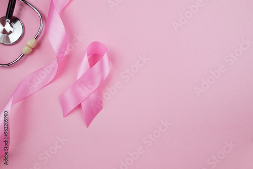 Top view photo of pink ribbon symbol of breast cancer awareness and stethoscope on isolated pastel pink background with copyspace