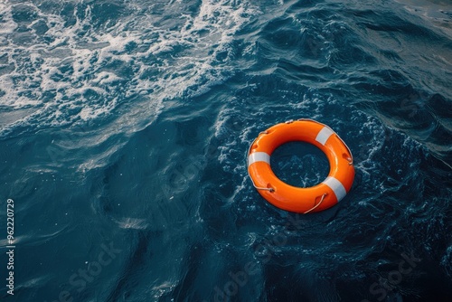 Orange lifebuoy floating in blue water. Represents safety and hope, perfect for websites or articles about nautical themes or crisis intervention.