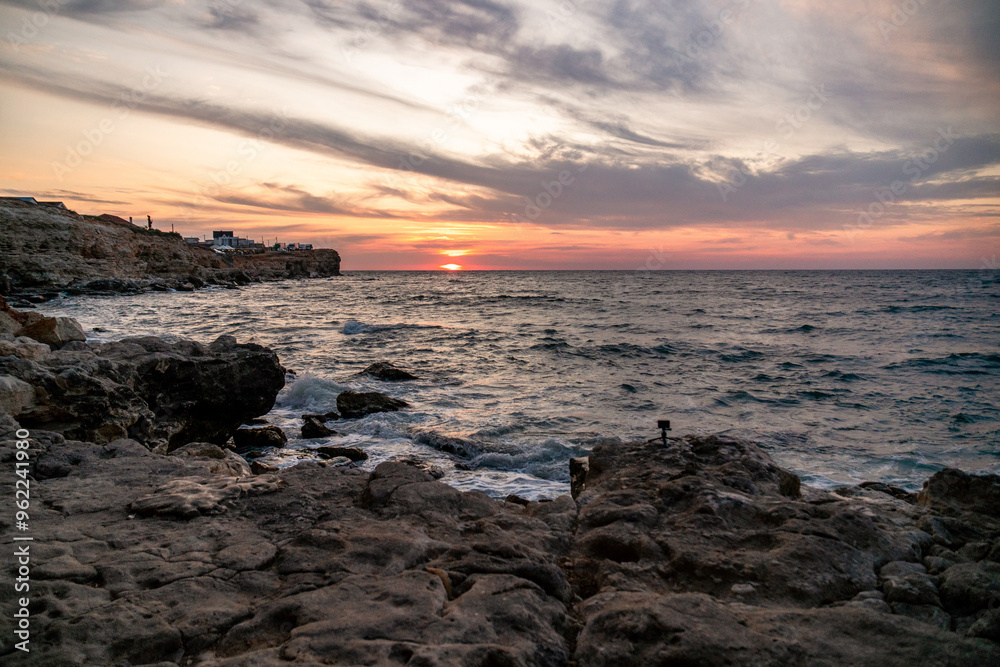 Sunset Sea Coastline Greece - A scenic view of a sunset over the sea with rocky coastline in Greece. Sunset Sea Coastline Greece - A scenic view of a sunset over the sea with rocky coastline in Greece.