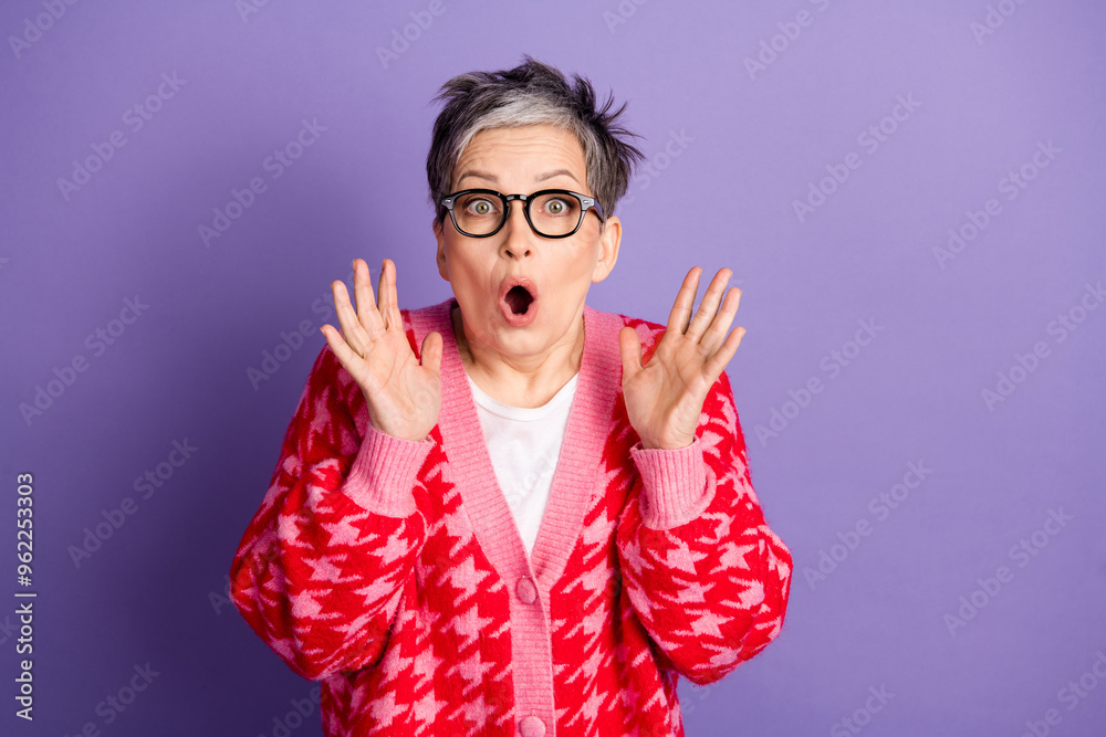 Photo portrait of lovely pensioner lady amazed excited raise hands dressed stylish red garment isolated on violet color background Photo portrait of lovely pensioner lady amazed excited raise hands dressed stylish red garment isolated on violet color background