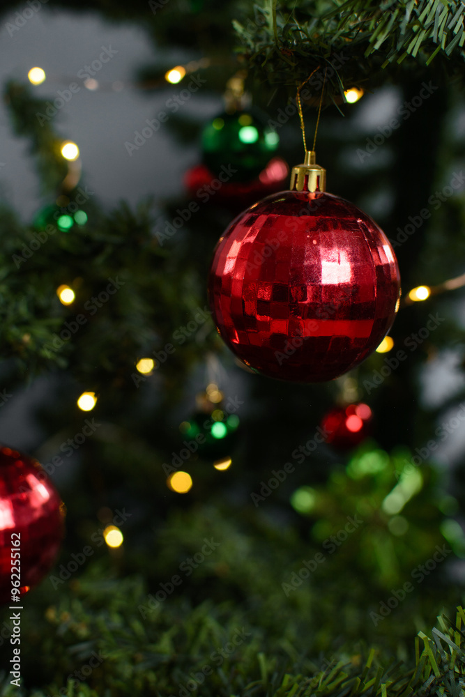 red Christmas decorations on a christmas tree, sparkly red christmas tree baubles on artificial tree, closeup view of red christmas tree ornaments