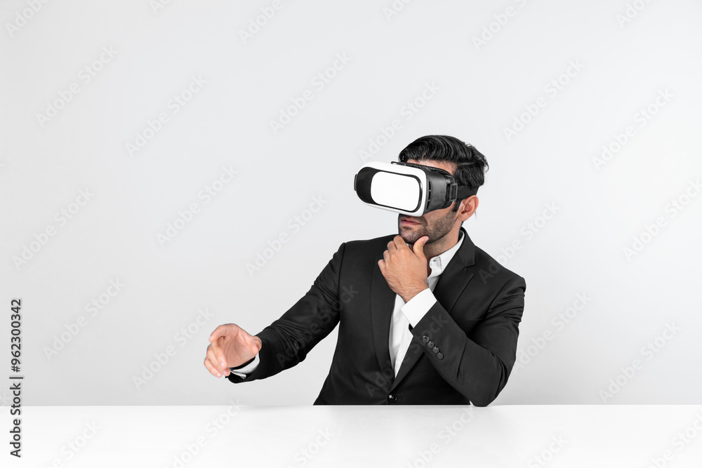 Professional businessman wearing visual reality glasses and suit while sitting. Smart caucasian project manager looking at data analysis by using VR headset. Innovation technology concept. Deviation. Professional businessman wearing visual reality glasses and suit while sitting. Smart caucasian project manager looking at data analysis by using VR headset. Innovation technology concept. Deviation.