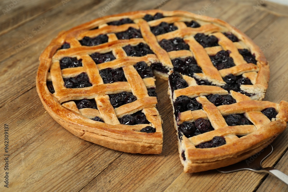 Taking piece of delicious homemade blueberry pie with server on wooden table Taking piece of delicious homemade blueberry pie with server on wooden table
