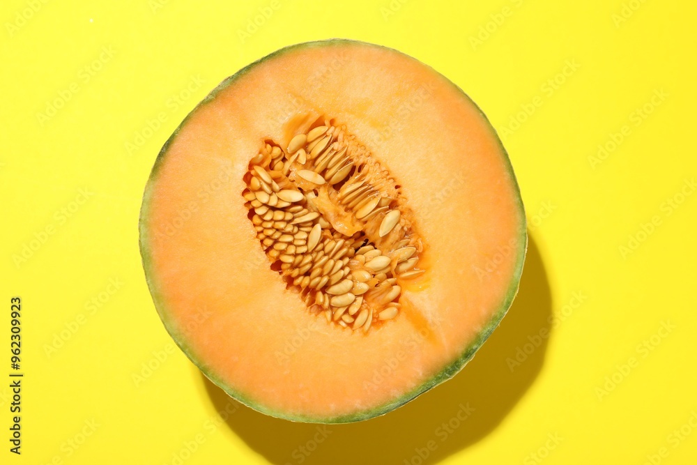 Half of fresh Cantaloupe melon on yellow table, top view Half of fresh Cantaloupe melon on yellow table, top view