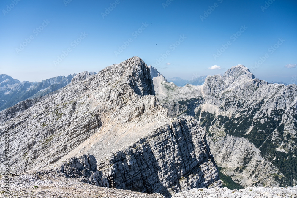 Φωτογραφία The majestic Velika Mojstrovka and Mangart mountains rise dramatically in the Julian Alps, showcasing their rugged beauty under a clear blue sky