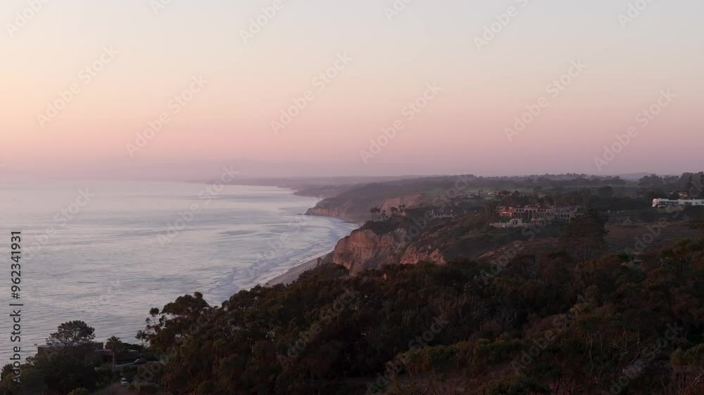 Stunning aerial view of the sun setting over the Pacific Ocean near La Jolla on a clear day with views of the beaches and cliffs along the Southern California coast with colorful red and orange sky Stunning aerial view of the sun setting over the Pacific Ocean near La Jolla on a clear day with views of the beaches and cliffs along the Southern California coast with colorful red and orange sky