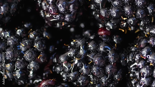 Blackberry berries. Fresh ripe blackberries as background, top view. Juicy ripe black berries in a heap. Texture of blackberries close-up. Slow motion, background rotation.