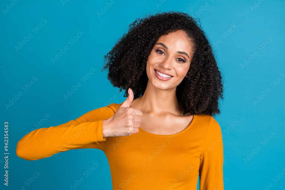Photo portrait of lovely young lady thumb up approve dressed stylish orange garment isolated on blue color background Photo portrait of lovely young lady thumb up approve dressed stylish orange garment isolated on blue color background