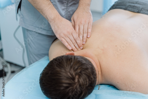 Therapist performing back massage therapy for muscle relaxation and tension relief in clinic