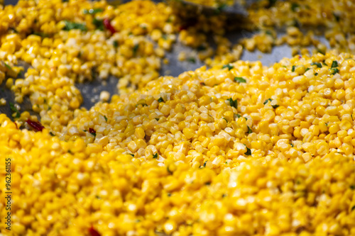 close up of yellow corn cooking on a metal plate  photo