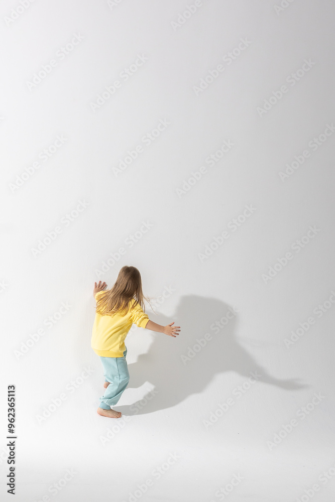 Portrait of beautiful cute little toddler girl. Child with funny face in yellow sweatshirt. Pretty smile kid in studio on white background. High quality photo Portrait of beautiful cute little toddler girl. Child with funny face in yellow sweatshirt. Pretty smile kid in studio on white background. High quality photo