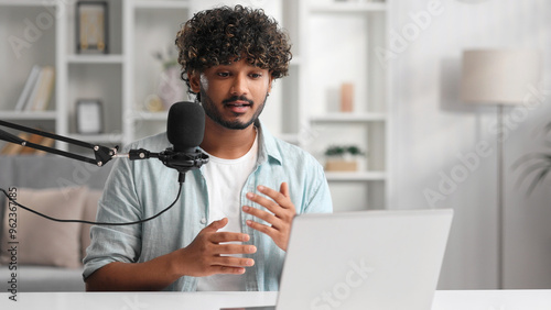 Microphone, podcast and Indian man speaker in his living room. Creative streamer, internet influencer or online content creator live streaming for audience.