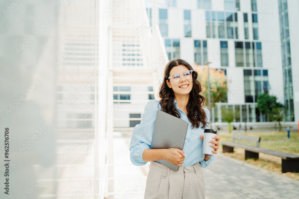 Fototapeta premium Young successful woman is going to work at modern business building 