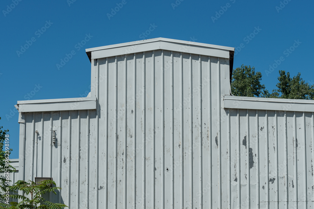 historic warehouse with metal-clad exterior on a blue sky with trees historic warehouse with metal-clad exterior on a blue sky with trees