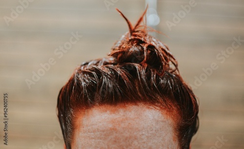 Vászonkép close-up of dyed red female hair in a bun on a brown background