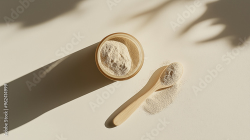 a bottle of lion's mane mushroom powder with a teaspoon of the powder against an isolated soft cream white background