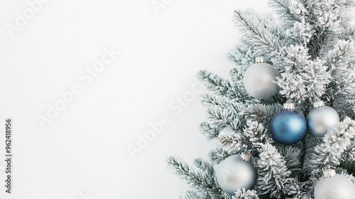 a frosted christmas tree with silver and blue ornaments against an isolated white background