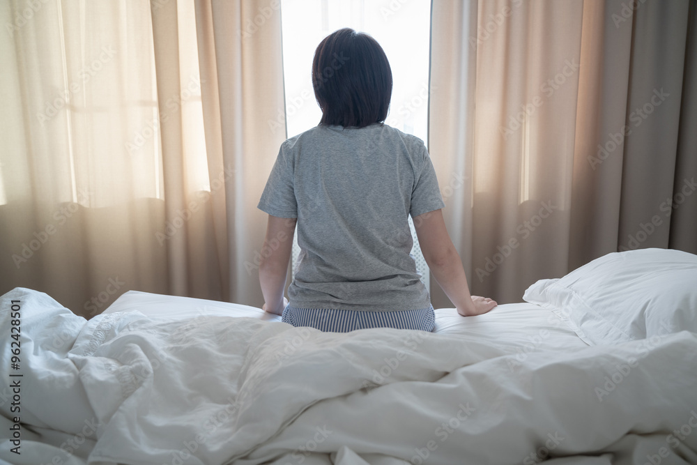Back view of woman feeling depression and sitting on the bed Back view of woman feeling depression and sitting on the bed