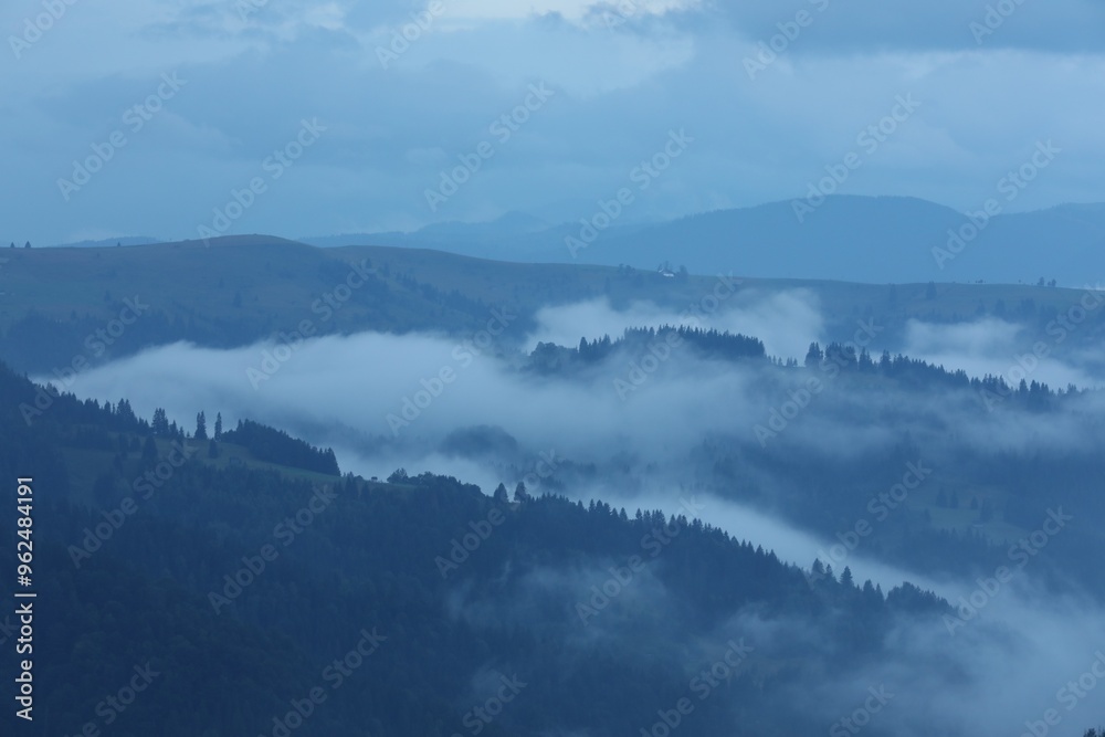 Obraz premium Picturesque view of beautiful mountains covered with fog