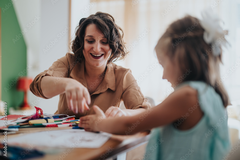 Fototapeta premium A joyful mom and her daughters engage in creative activities at home. They are surrounded by art supplies, fostering bonding and creativity in a cozy environment.