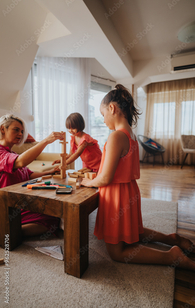 A loving mother and her two daughters engage in creative play at home, building with wooden blocks. The warm, cozy setting emphasizes family bonding and togetherness.