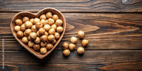 Macadamia nuts in heart-shaped bowl on wooden table, top view, macadamia nuts, heart-shaped, ceramic bowl