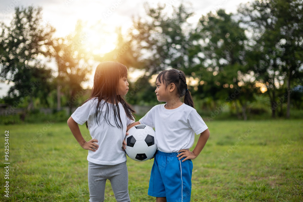 Two young girls are standing in a grassy field Two young girls are standing in a grassy field