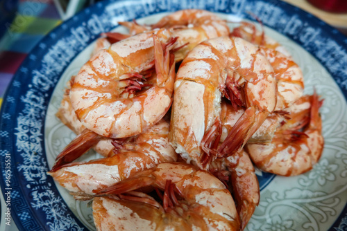 close up of Chinese Hong Kong Cantonese style homemade boiled steamed seafood shrimp prawns in orange on a blue plate photo