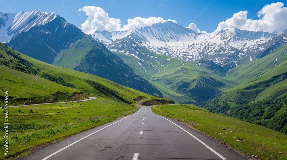 Naklejka premium Winding Road Through Mountain Pass with Green Hills and Snow Peaks