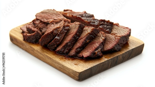 A slab of meat is cut into thin slices and is sitting on a wooden cutting board