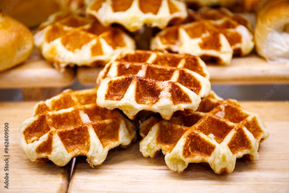 Golden brown Belgian waffles stacked on a wooden board, showcasing their crispy exterior and soft, fluffy texture. Perfect for breakfast or a sweet snack. Golden brown Belgian waffles stacked on a wooden board, showcasing their crispy exterior and soft, fluffy texture. Perfect for breakfast or a sweet snack.