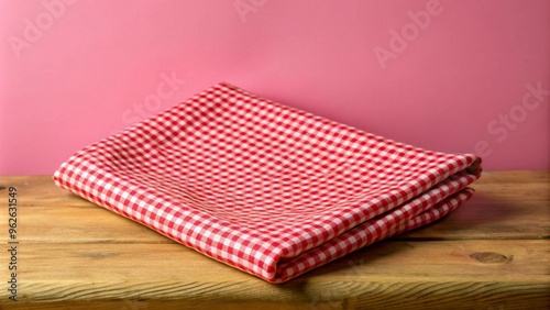 Red checked fabric cloth on wooden table countertop, isolated with no objects around. Simple background.