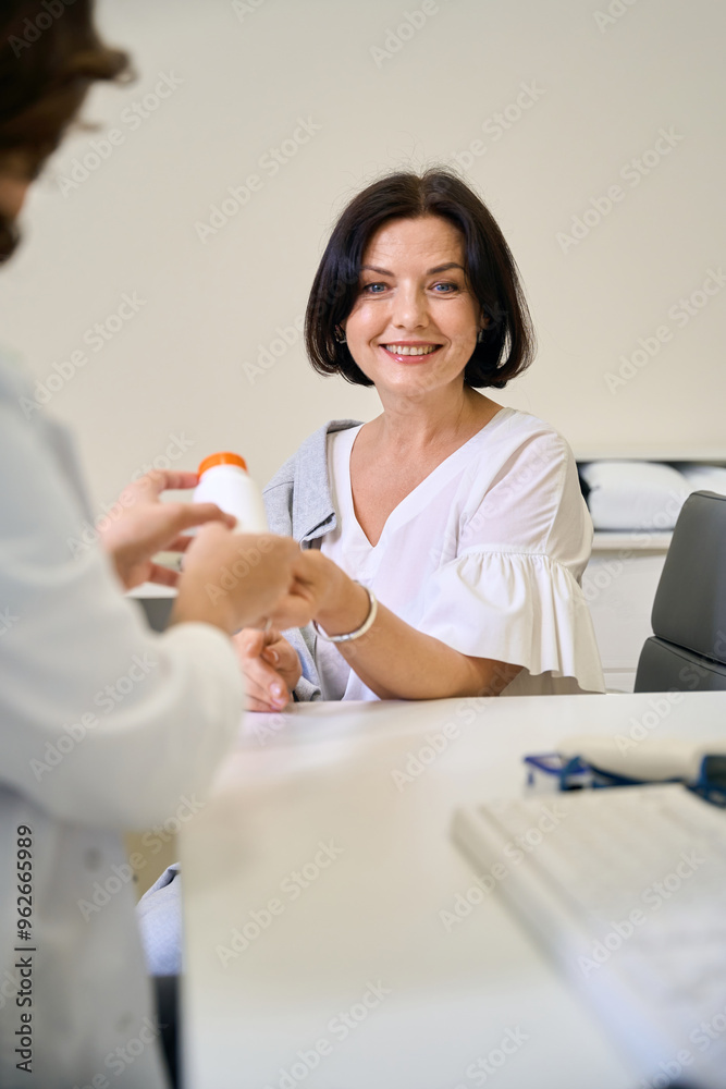 Smiling woman communicates with a phlebologist in a clinic Smiling woman communicates with a phlebologist in a clinic