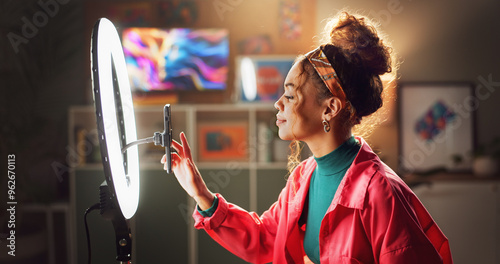 Woman, influencer and phone with ring light for video recording, vlogging or online tutorial at home. Young, female person or vlogger setting up mobile smartphone for advice, tips or content creation photo