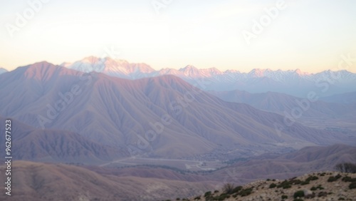 A mountain range bathed in the soft light of sunrise.