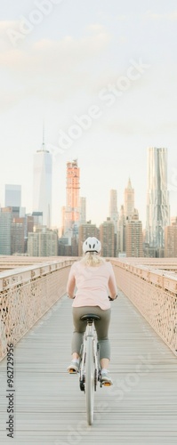 Female Cyclist on Bridge with Urban Skyline - Modern Urban Commuting and Sport photo