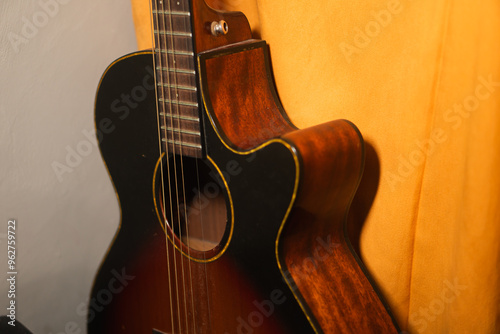 Canvas Print Close-up of an Acoustic Guitar Against Yellow Curtain