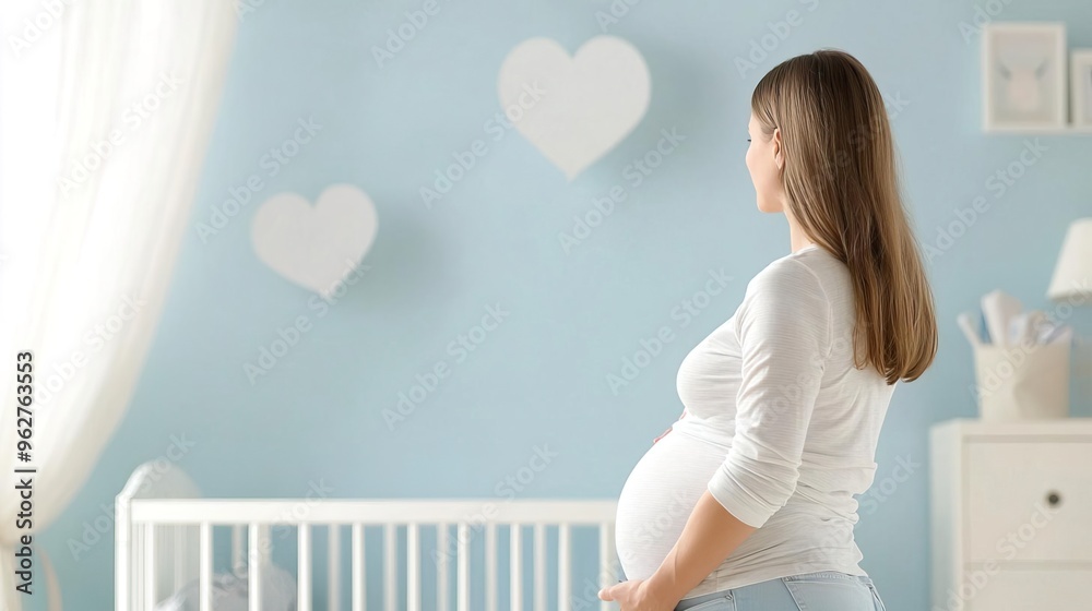 Pregnant woman in a nursery with a crib and blue walls.