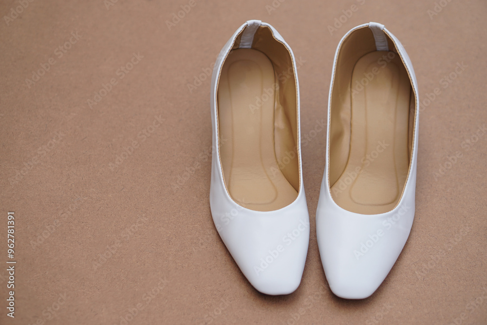 Pair iof white shoes on brown background. Concept, fashion, formal and polite footwears for office workers or nurses to wear shoes in office or hospital to match with white uniform. Footwears. Pair iof white shoes on brown background. Concept, fashion, formal and polite footwears for office workers or nurses to wear shoes in office or hospital to match with white uniform. Footwears.