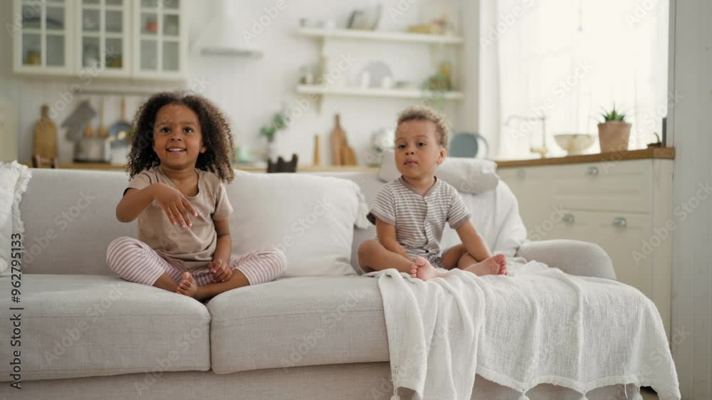 Happy African siblings sitting on couch in room and playing with balloons. Cheerful black children having fun together, happy childhood, family concept, charming little kids at home with cozy interior Happy African siblings sitting on couch in room and playing with balloons. Cheerful black children having fun together, happy childhood, family concept, charming little kids at home with cozy interior