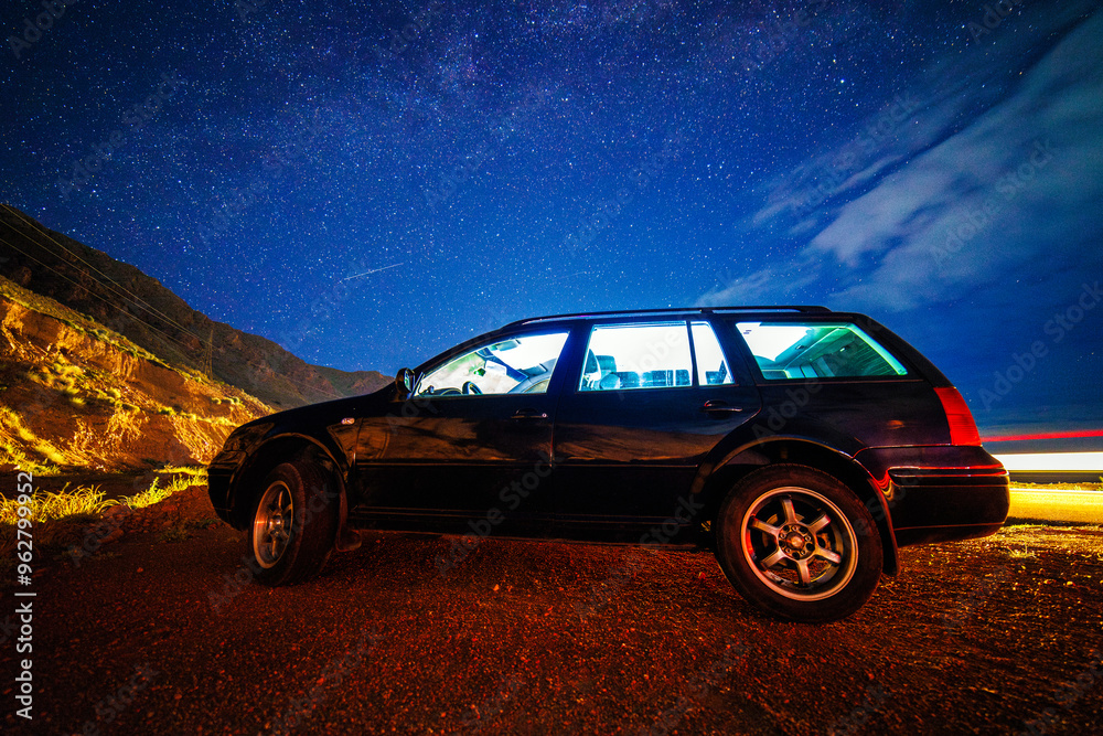 old black German station wagon car at starry summer night in the desert