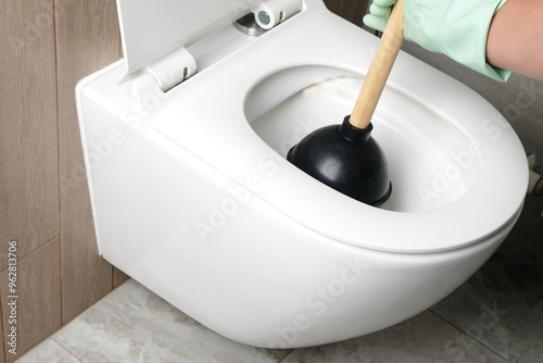 Close-up of the process of unclogging a toilet with a plunger