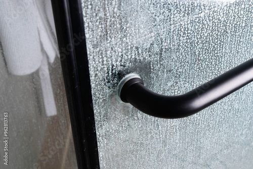 Limescale on transparent glass of shower cabin close-up, plumbing maintenance concept