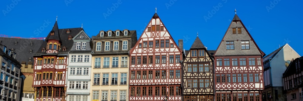 Fototapeta premium Traditional half-timbered houses against a clear blue sky in Frankfurt, Germany, capturing historic European architecture, ideal for travel concepts