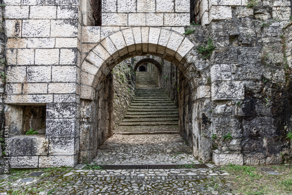 custom made wallpaper toronto digitalArchway leading into Strada del Soccorso in Brescia castle with detailed stone textures. The composition highlights the depth of the staircase and arch