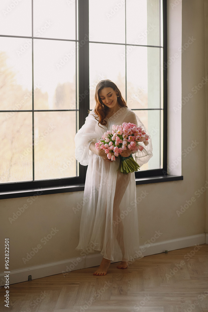 Portrait of pregnant woman in white dress with bouquet of tulips Portrait of pregnant woman in white dress with bouquet of tulips