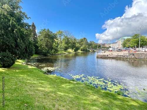 Beautiful cityscape of a river with water lilies and a picturesque park on a sunny day in Gothenburg, Sweden
