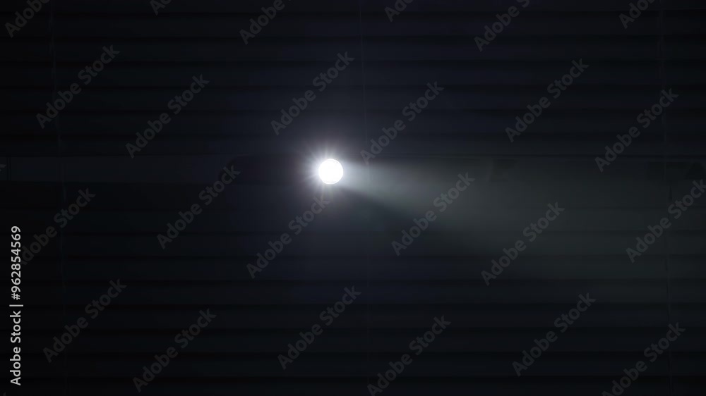 crime and robbery concept, male thief with flashlight looking for help through blinds against police lights background, close up