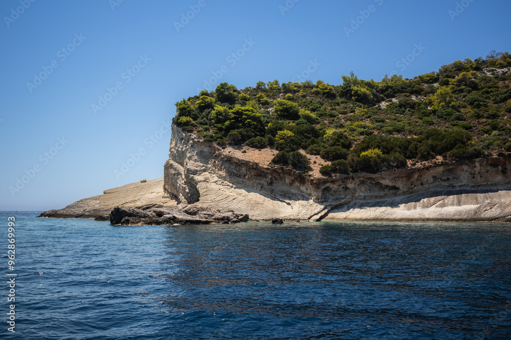 Beautiful Summer Landscape with Rocky Coast in Zakynthos. Sunny View of Greek Island. Ionian Sea with Stony Shore with Green Trees in Greece. Beautiful Summer Landscape with Rocky Coast in Zakynthos. Sunny View of Greek Island. Ionian Sea with Stony Shore with Green Trees in Greece.