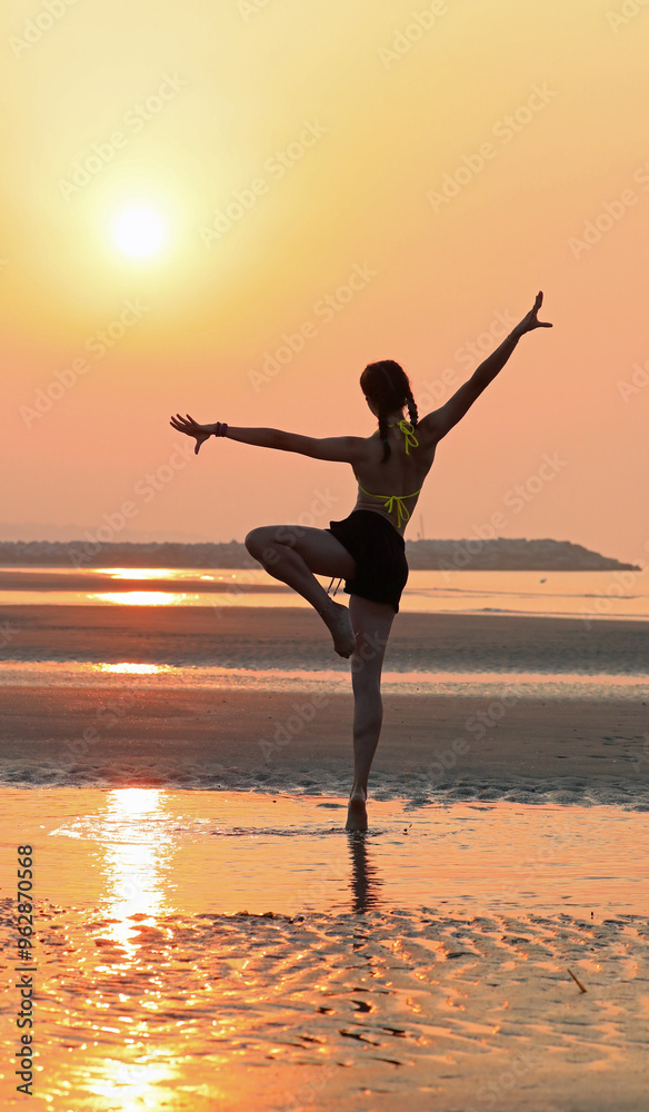 young girl in backlight doing gymnastics on the seashore expressing joy and happiness young girl in backlight doing gymnastics on the seashore expressing joy and happiness